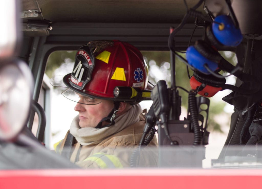 Molalla firefighter in cab of fire apparatus.