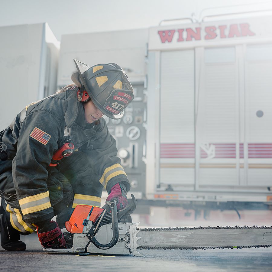 Firefighter wearing a headset and operating saw